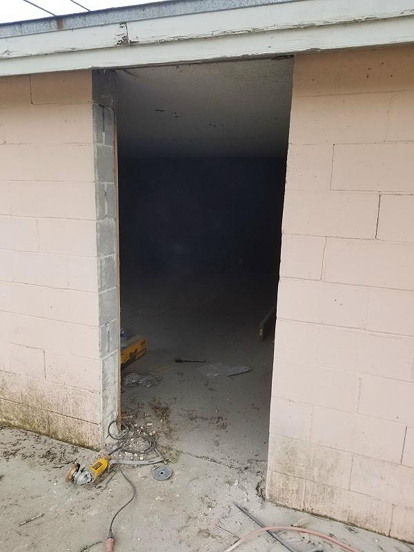 Door frame removed - cleaning up the concrete with a grinder