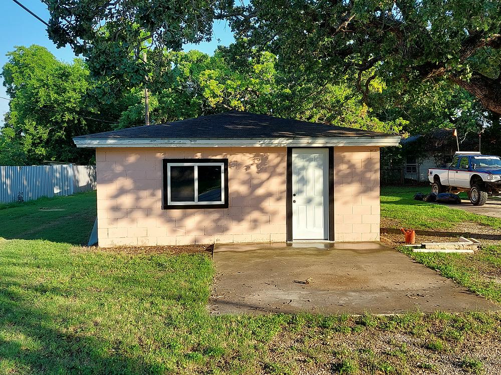Street view of the building with a new window and door